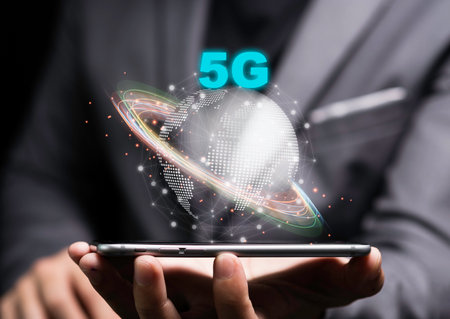 5G and internet of things or IOT concept, Businessman holding smartphone with 5G on world. IOT is high technology which every device will connect and control by 5G high speed internet.の写真素材