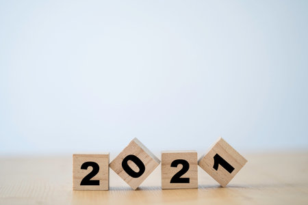 Flipping of wooden cubes block of 2021 year. Merry Christmas and happy new year concept.