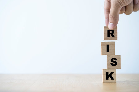 Risk management concept ,Hand putting wooden cube block which print screen risk wording.