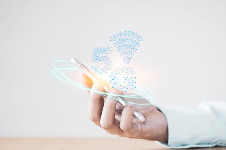 5G and internet of things or IOT concept, Hand holding smartphone with virtual 5G signal. IOT is...