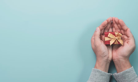 Businessman holding red gift box with gold ribbon for give present to lover , Merry Christmas Happy new year and valentine's day concept.の写真素材