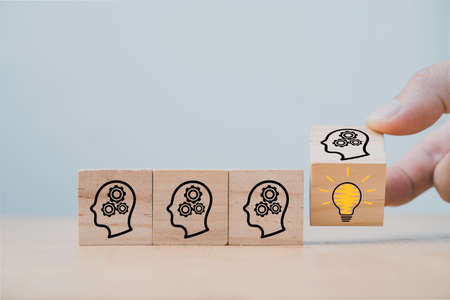 Hand flipping wooden cube block which print screen face with questions mark to lightbulb, creative idea and innovation concept.の写真素材