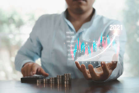 Business investor holding virtual stock market chart and using calculator  to analysis , business...