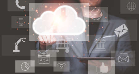 Businessman holding tablet and touching virtual cloud computing with technology icons s. Cloud...