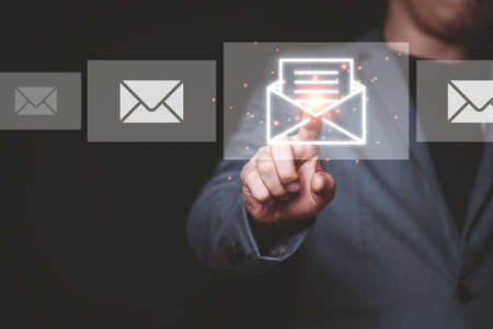 Businessman touching virtual E-mail to open and reading.の写真素材