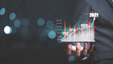 Businessman holding smartphone with info graphics virtual business investment chart and copy space.