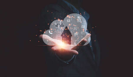 Businessman holding virtual cloud computer with icons for download and upload application, technology transformation and innovation concept.の写真素材