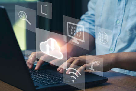 Businessman using laptop computer to control operations thru cloud computing system.