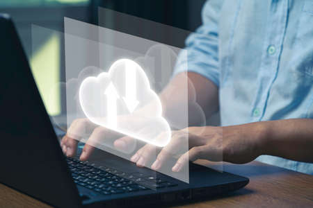 Virtual Cloud and technology icons , Businessman using laptop computer to control operations thru cloud computing system.の写真素材