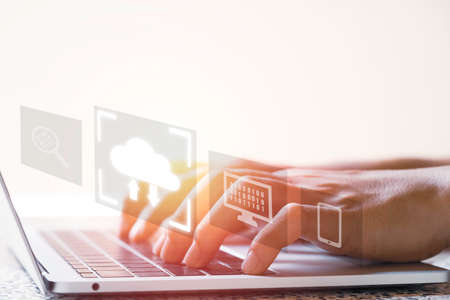 Virtual Cloud and technology icons , Businessman using laptop computer to control operations thru cloud computing system.の写真素材