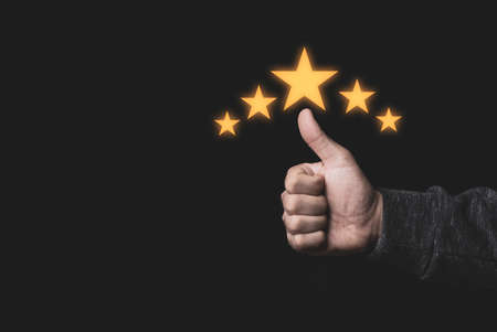 Hand and thumb rise up with five yellow stars on black background, the best customer satisfaction...
