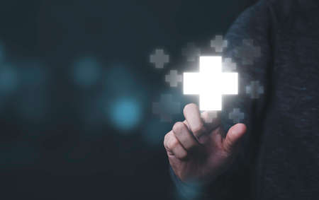 Businessman touching to virtual plus sign which it mean positive sign such as add more benefit thinking and mindset concept.の写真素材