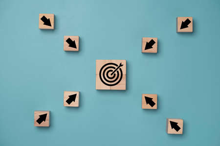 Center Virtual target board on blue background and arrow which print screen on wooden cube. Business achievement goal and objective target concept.の写真素材