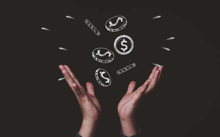 Two hands receive dollar money coins drawing which fallen from sky , Making money and business wealth concept.の写真素材