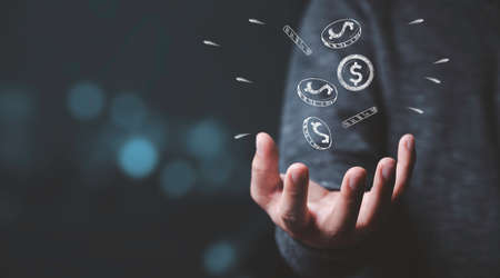 Businessman hand received dollar money coins drawing which fallen from sky , Making money and business wealth concept.の写真素材