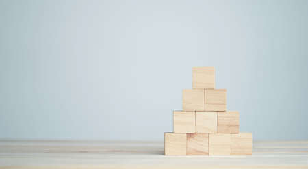 stacking blank wooden cubes on table with copy space for input wording and infographic icon.