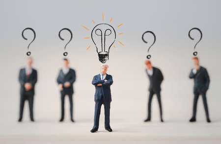 Miniature figure businessmen with glowing light bulb and question mark , Thinking idea and problem solving concept.の写真素材