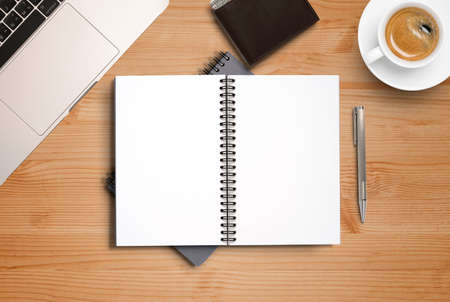Top view of blank notebook memo on working desk among coffee cup and laptop , workplace concept.