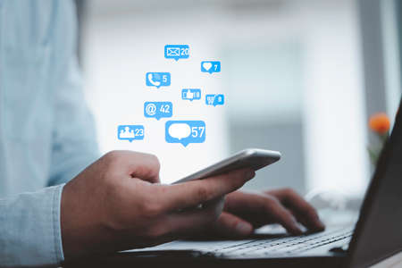 Man holding smartphone with Social media and business icons , technology and marketing concept.の写真素材