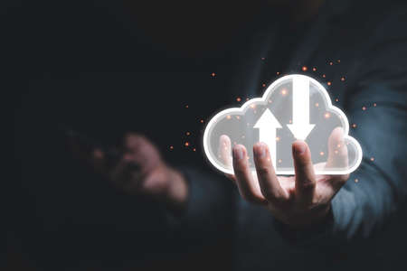 Businessman holding white cloud computing icon from hand drawing with blue bokeh background , Cloud...