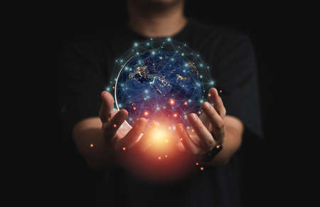 Businessman holding virtual world with orange light and connection line for global telecommunications concept.の写真素材