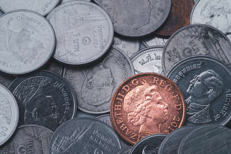 Bronze pound sterling coin on others coins background , Currency exchange saving and investment...