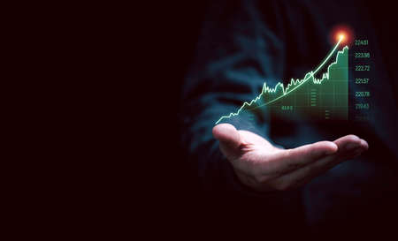 Businessman hand holding increasing virtual investment graph and chart for stock market analysis...