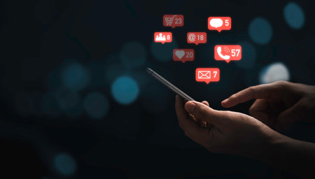 Hand using smartphone to send message and social media icons with blue bokeh background for...