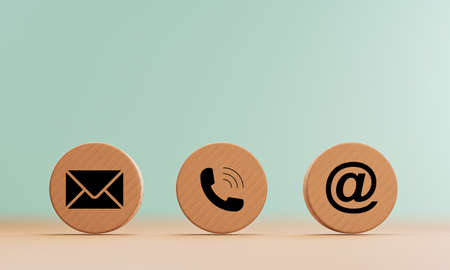 E-mail address ,telephone number and letter icons print screen on circle wooden block on table for webpage business contact and customer service concept by 3d rendering.の写真素材
