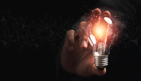 Businessman holding lightbulb glowing with connection line for creative thinking ideas and innovation concept.の写真素材