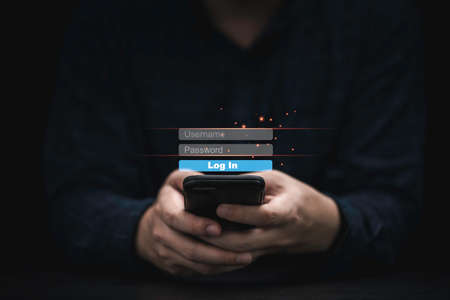 Businessman holding smartphone and input user name and password for login or access to mobile phone , Technology security concept.の写真素材