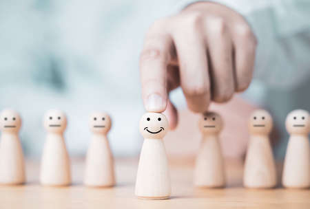 Businessman pointing and pushing wooden model in front of others model for leadership and promotion concept.の写真素材