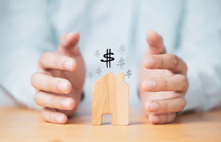 Businessman hand protecting house model for insurance of asset concept.の写真素材