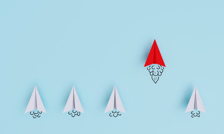 Red paper plane flying and leading white plane for leadership and business competition concept on blue background by 3d rendering.の写真素材