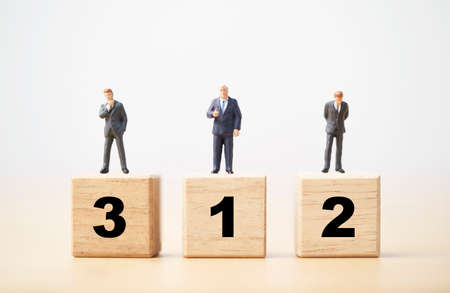 Businessman figure standing on wooden podium number 1 2 and 3 for business ranking competition concept.の写真素材