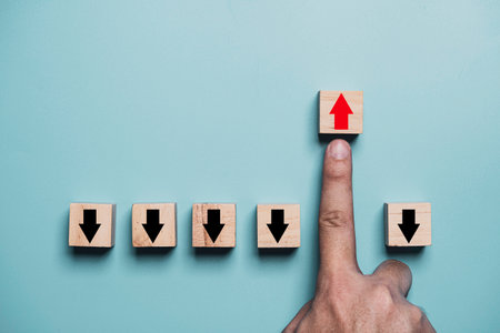 Finger pushing red up arrow which it opposite direction from black down arrow for business disruption and leadership concept.の写真素材