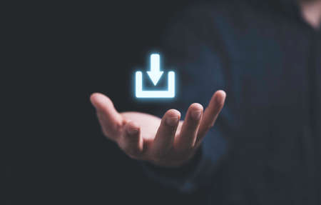 Hand holding virtual download sign symbol for technology transformation and sharing concept.の写真素材