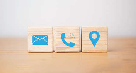Blue  letter telephone location and address icons print screen on wooden cube block for customer service contact concept.の写真素材