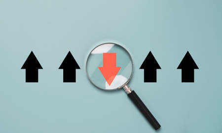 Red arrow inside of magnifier glass and different direction from white arrow for focus business disruption and technology transformation concept.の写真素材