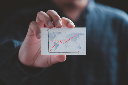 Businessman holding white paper with increasing graph and world map for economy inflation after covid-19 pandemic concept.の写真素材