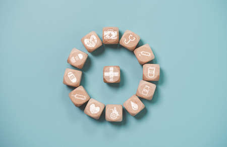 Wooden block cube which print screen health care and medical icons for healthy and wellness concept.