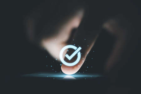 Hand touching to screen with tick correct mark to approve document and project concept.の写真素材