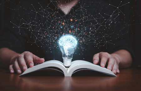 Glowing lightbulb with virtual brain on open book  and connection line for reading and education make smart or creative thinking idea concept.の写真素材