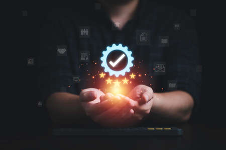 Businessman holding and showing the best quality assurance with golden five stars and icons for...