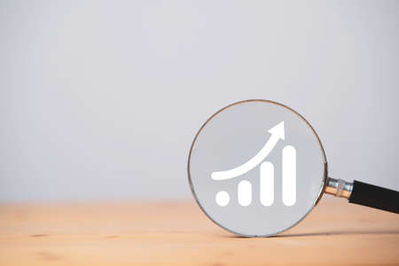 White growth graph and chart on magnifier glass with copy space for focus sale business increase concept.の写真素材
