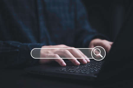 Man typing to keyboard with search engine bar for SEO or Search Engine Optimisation of marketing...