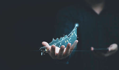 Businessman hand holding virtual stock market graph chart for trader technical analysis business...