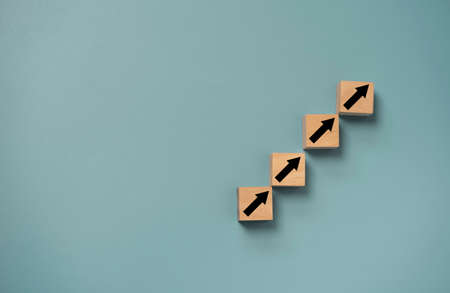Up arrow which print screen on wooden cube block for business investment ,financial interest  increasing rate and career path growth concept.の写真素材