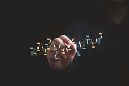 Businessman hand writing stock market graph chart gain profit , Business investment planing growth and economic increasing strategy concept.の写真素材