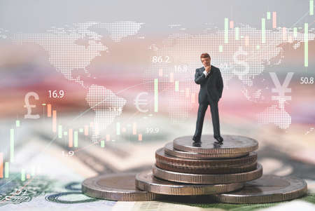 Businessmen miniature figure standing on coins stacking with stock market graph chart for money saving to investment growth planing strategy concept.の写真素材